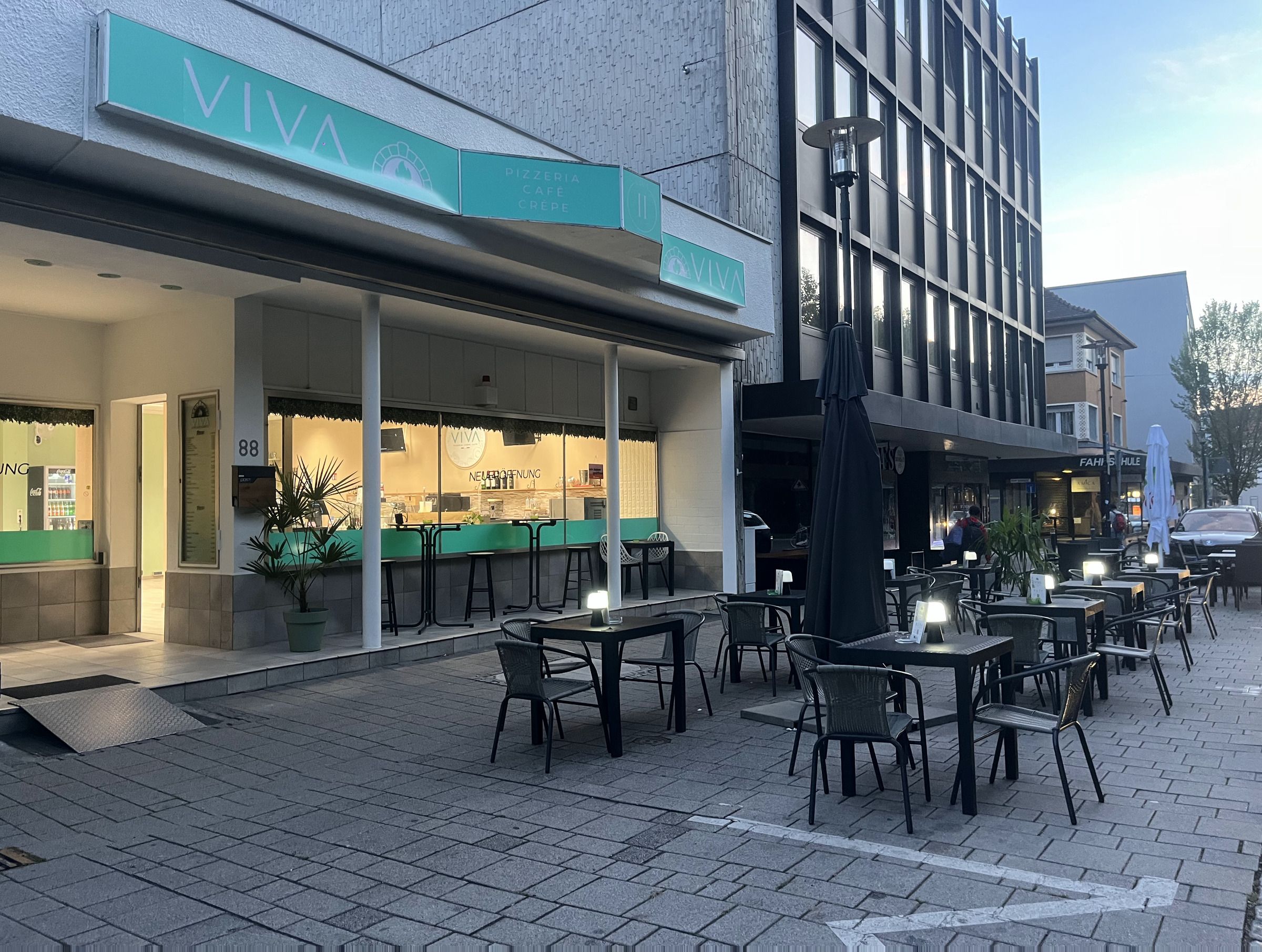 Der Eingang zu VIVA in der Bahnhofstraße 88 mit Sitzplätzen vor dem Laden